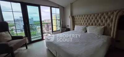 Luxurious bedroom with large windows offering stunning city views and elegant furnishings.