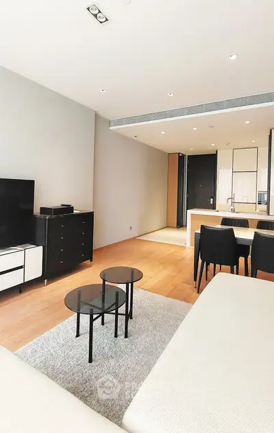 Modern living room with open kitchen, sleek furniture, and stylish decor in a contemporary apartment.