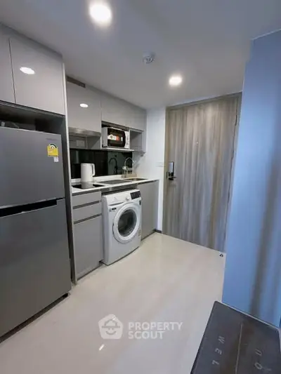 Modern compact kitchen with washing machine and stainless steel fridge