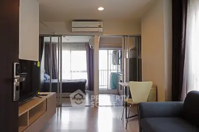 Modern apartment interior with open layout, featuring a cozy living area and a glimpse of the bedroom.