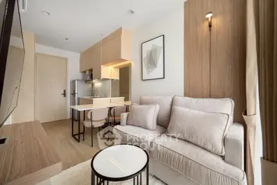 Modern living room with open kitchen, stylish decor, and cozy seating in a contemporary apartment.