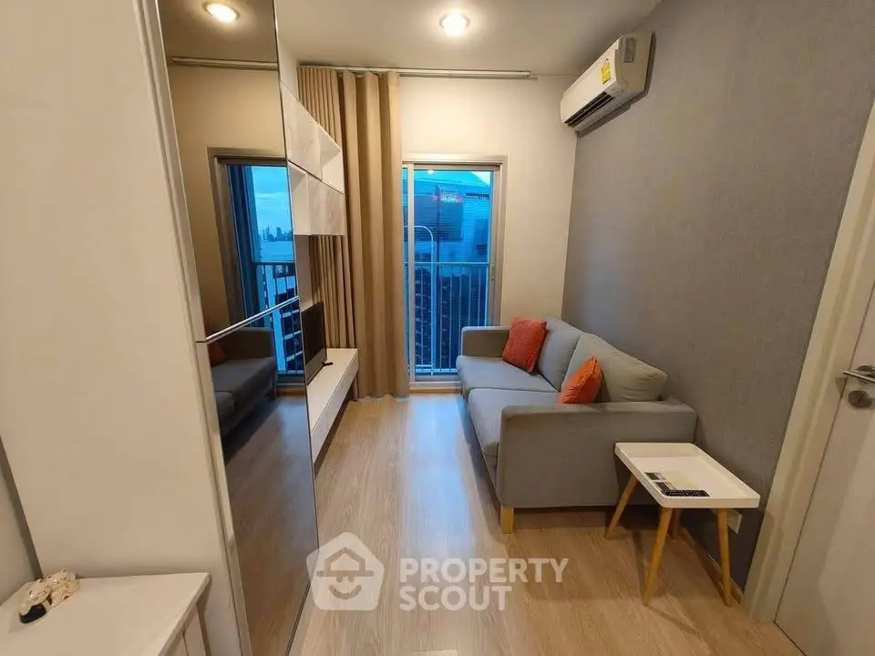 Modern living room with cozy sofa and city view from balcony, perfect for urban living.