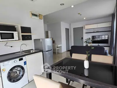 Modern open-plan living room with kitchen, dining area, and stylish furniture in a bright apartment.