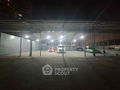 Spacious covered parking area with multiple cars at night, well-lit and secure.