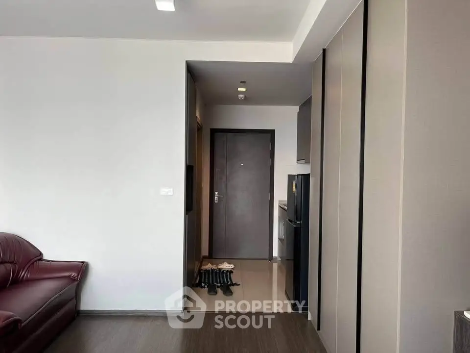 Modern apartment interior with sleek kitchen and cozy living area, featuring stylish flooring and contemporary design.