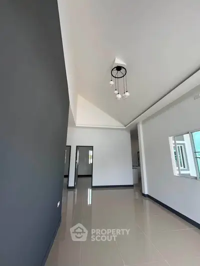 Spacious modern living room with high ceilings and elegant lighting in a contemporary home.