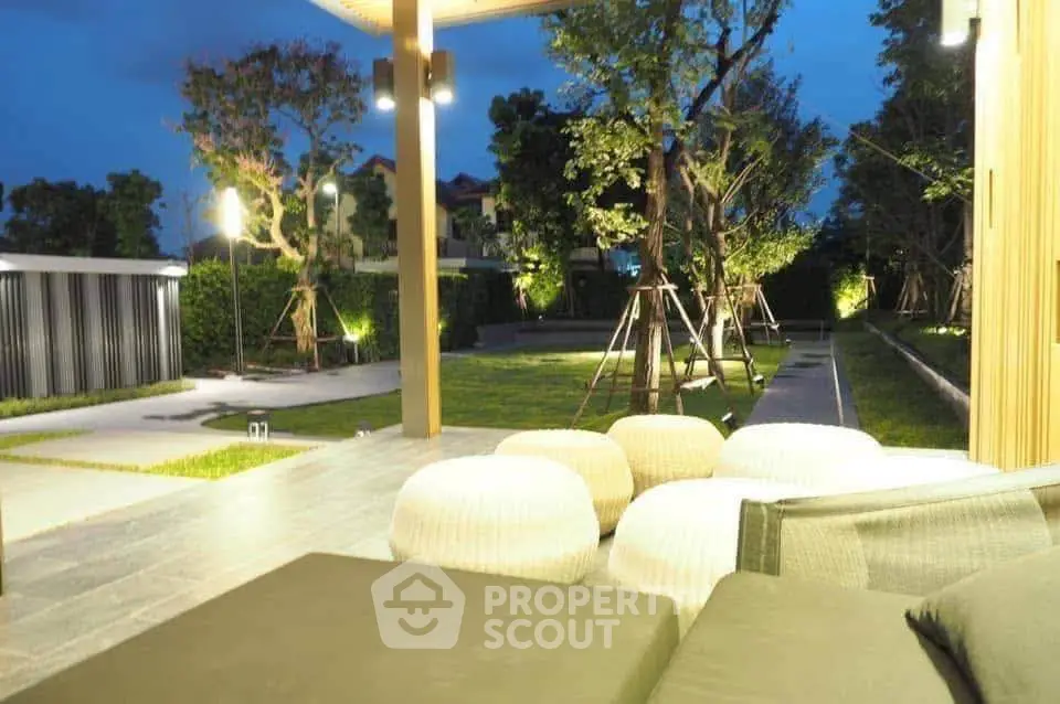 Luxurious outdoor garden with stylish seating and ambient lighting for serene evenings.