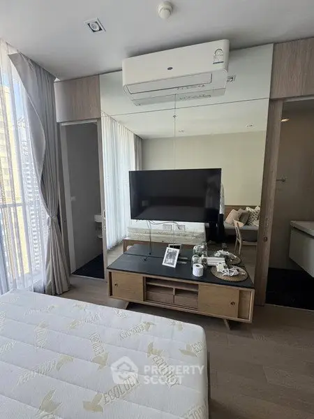 Modern bedroom with sleek design, featuring a wall-mounted TV and air conditioning, perfect for urban living.