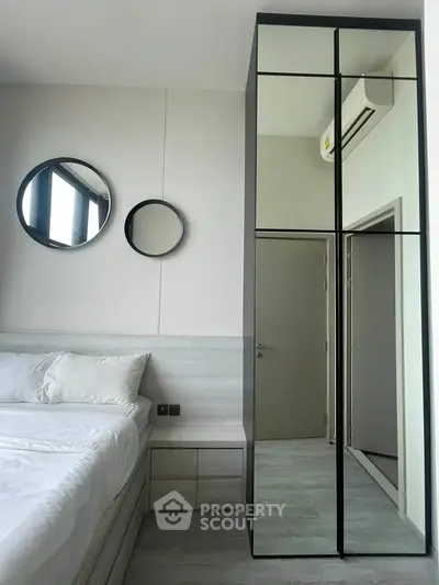 Modern bedroom with sleek mirrored wardrobe and stylish decor