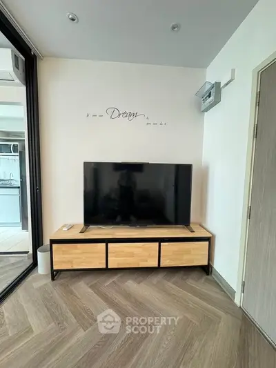 Modern living room with stylish TV stand and wall decor in a cozy apartment setting.