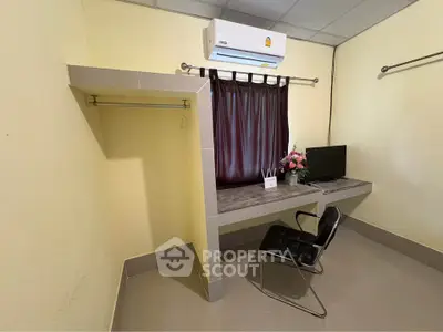 Compact study room with desk, chair, air conditioning, and window curtain.