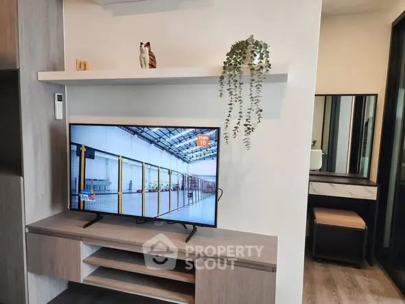 Modern living room with sleek TV unit and decorative shelves, perfect for stylish urban living.