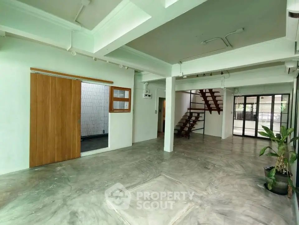 Spacious open-plan living area with modern staircase and large windows