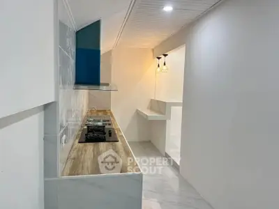 Modern kitchen with sleek design and gas stove, featuring elegant lighting and wooden countertops.