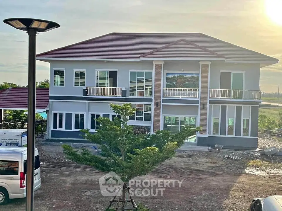 Stunning two-story modern house with large windows and a spacious balcony, perfect for family living.