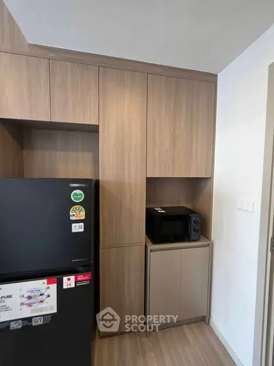 Modern kitchen with sleek wooden cabinets and built-in microwave
