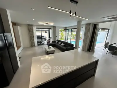 Spacious modern living room with pool view and sleek kitchen island