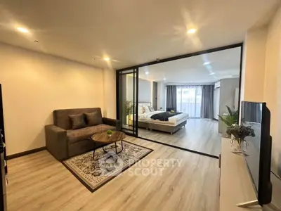 Modern open-plan living room with stylish decor and cozy bedroom view
