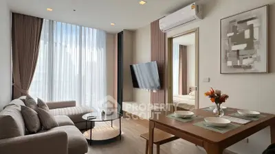 Modern living room with stylish decor, large windows, and open dining area in a contemporary apartment.