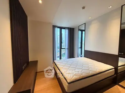 Modern bedroom with large windows and city view, featuring a comfortable bed and sleek design.