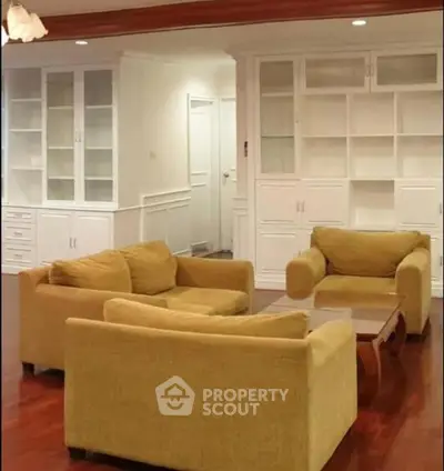 Spacious living room with elegant built-in shelves and cozy yellow sofas.