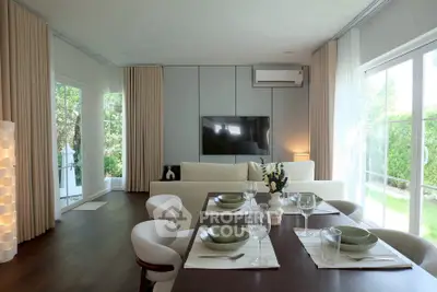Modern living room with elegant dining area and large windows overlooking garden