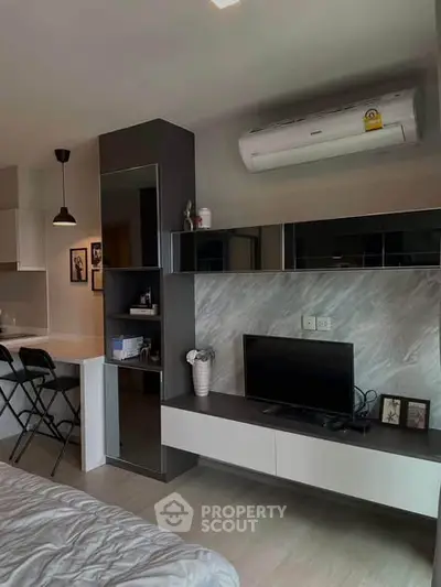 Modern studio apartment with sleek design and integrated air conditioning, featuring a cozy living area and stylish decor.