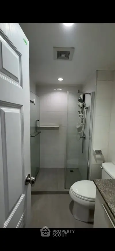 Modern bathroom with glass shower and sleek fixtures in a contemporary home.