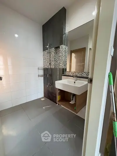 Modern bathroom with sleek tiles and stylish sink in real estate property.