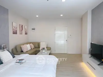 Spacious modern bedroom with cozy seating area and stylish decor