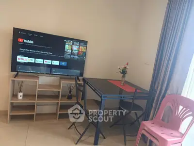 Cozy living room with modern TV setup and dining area, perfect for relaxation and entertainment.