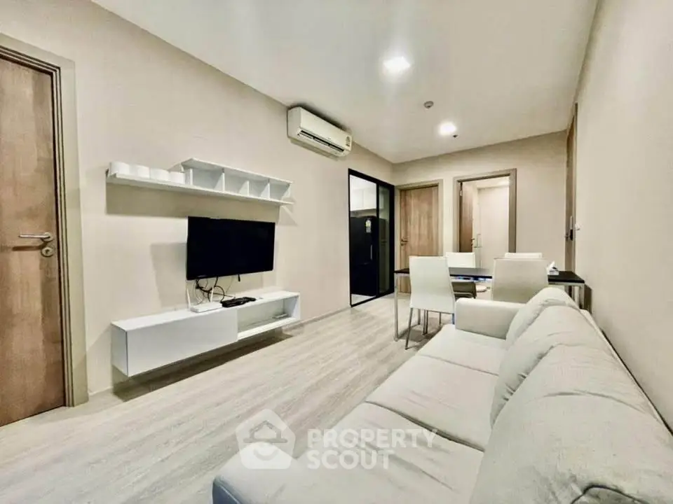 Modern living room with sleek furniture and mounted TV in a cozy apartment.
