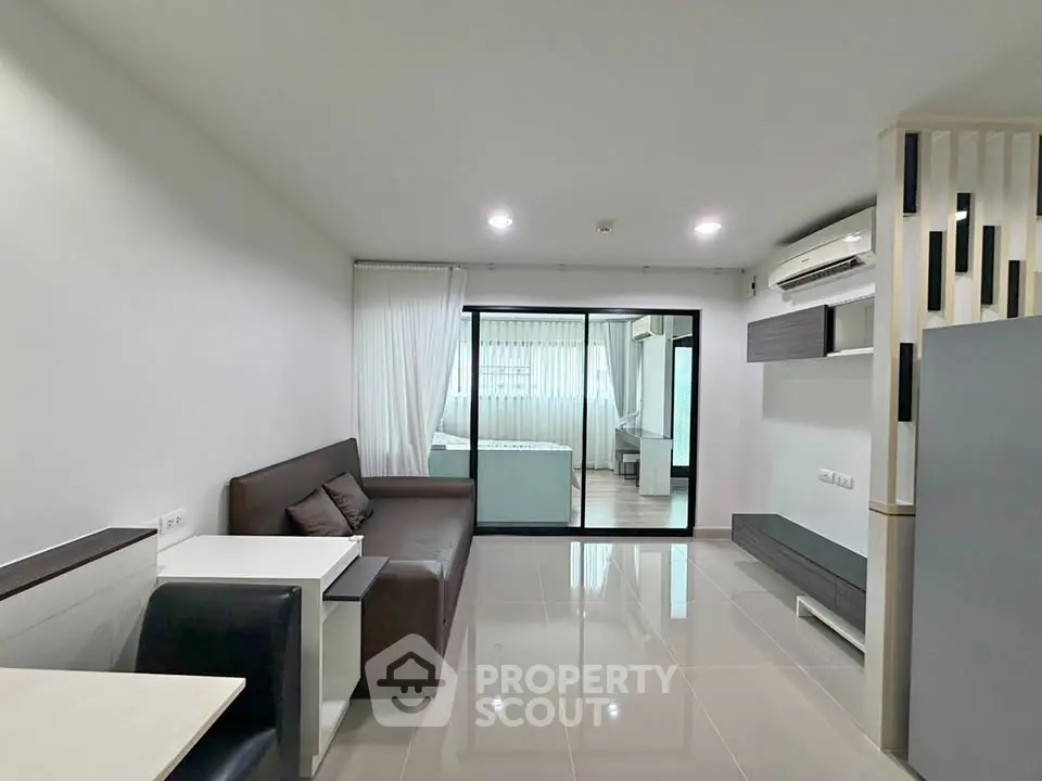 Modern living room with sleek design and open layout, featuring a cozy sofa and stylish decor.