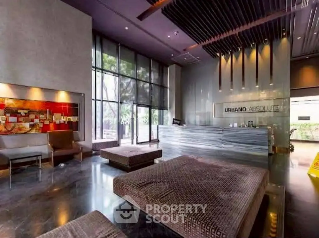 Luxurious modern lobby with stylish seating and large windows in upscale building.
