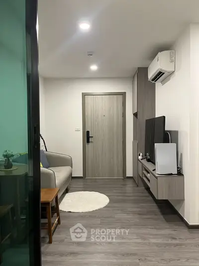 Modern living room with sleek design, featuring a cozy sofa, wall-mounted TV, and stylish decor.