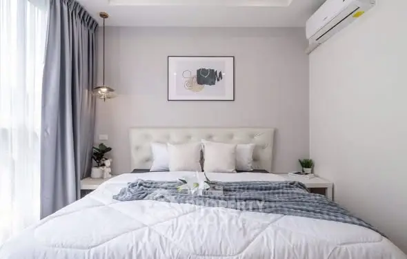 Modern bedroom with stylish decor and natural light, featuring a cozy bed and elegant furnishings.