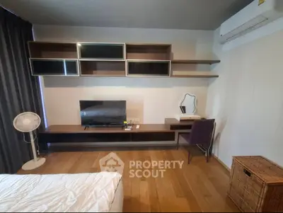 Modern bedroom with stylish shelving and air conditioning, featuring a cozy workspace and TV setup.