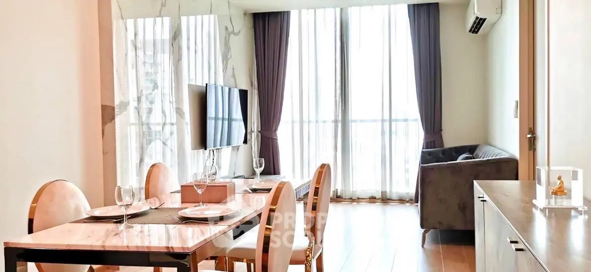 Elegant dining and living area with modern decor and large windows