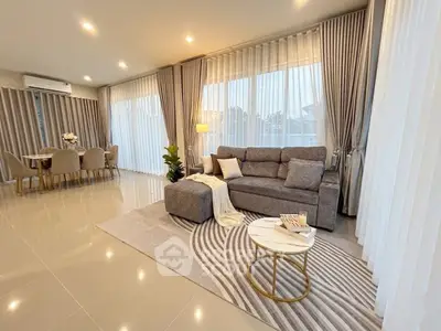 Spacious modern living room with elegant decor and large windows offering natural light.