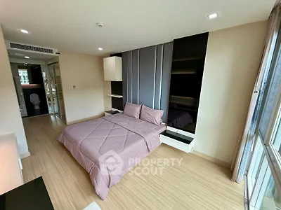 Spacious modern bedroom with large windows and elegant decor in a luxury apartment.