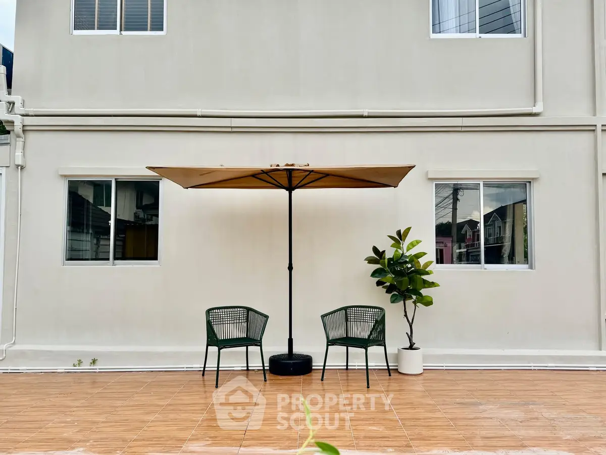 Charming outdoor patio with umbrella and seating, perfect for relaxation and entertaining.