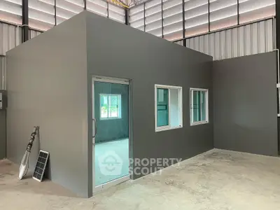 Modern industrial interior with sleek gray walls and large windows