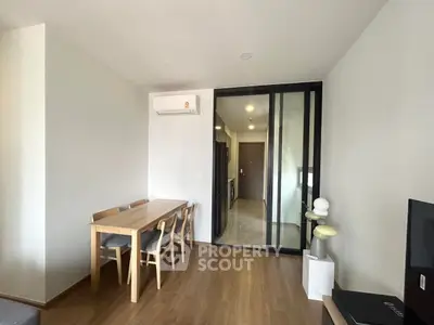 Modern dining area with wooden table and chairs, adjacent to a sleek kitchen.
