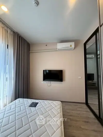 Modern bedroom with wall-mounted TV and air conditioning, featuring large window and sleek design.