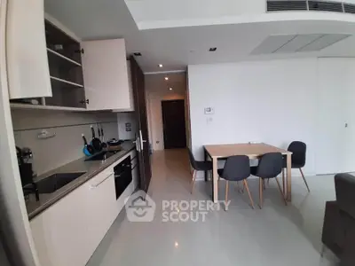 Modern open-layout kitchen and dining area with sleek cabinetry and contemporary furniture.