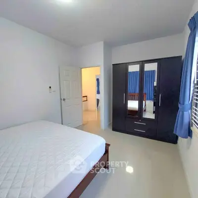 Spacious bedroom with modern wardrobe and natural light