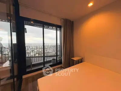 Modern bedroom with balcony offering stunning city views, featuring sleek design and ample natural light.