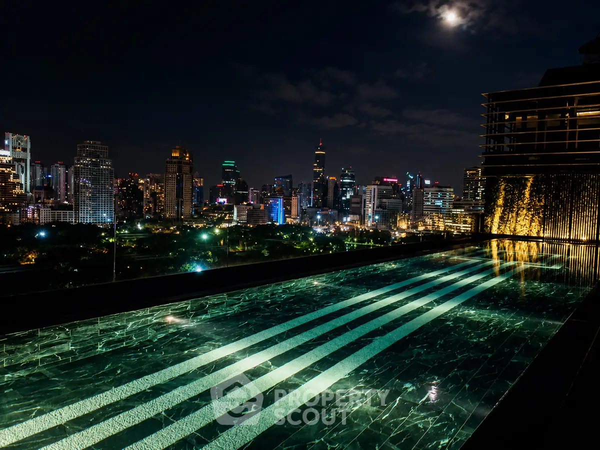 Luxurious rooftop pool with stunning city skyline view at night, perfect for urban living enthusiasts.