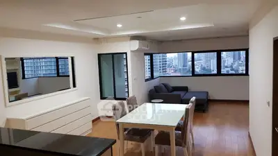Spacious modern living room with city view, featuring sleek furniture and ample natural light.