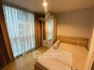 Cozy bedroom with large window and modern wardrobe in a stylish apartment.